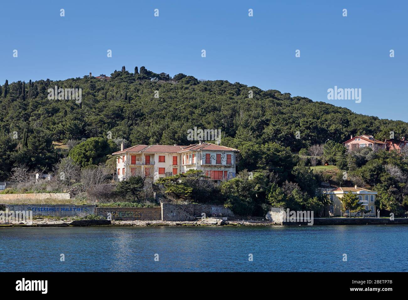 Istanbul, Turkey - February 13, 2020: An abandoned summer cottage with boarded up windows stands on a hillside, on the shores of the Sea of Marmara on Stock Photo