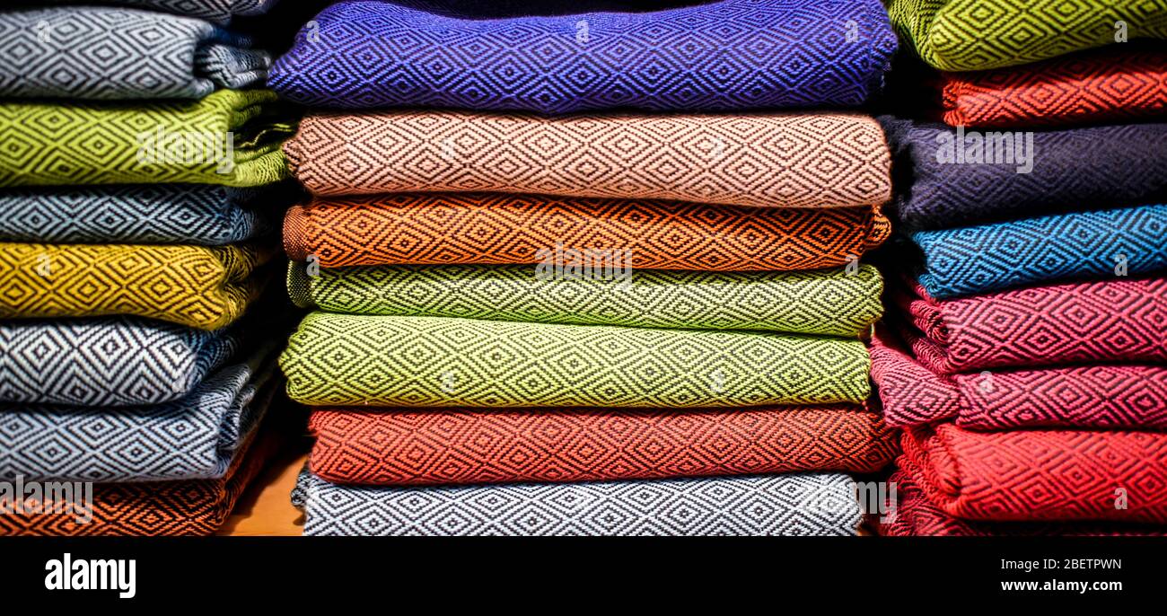 stacked multicolored clothing fabric in the closet bed linen banner. Stock Photo
