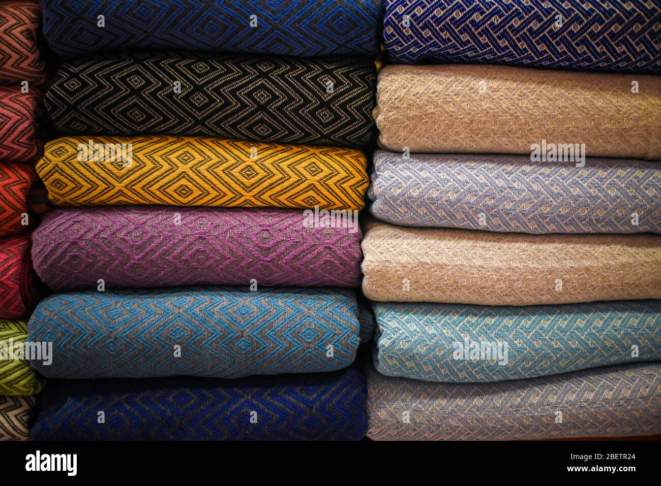 stacked multicolored clothing fabric in the closet bed linen banner. Stock Photo