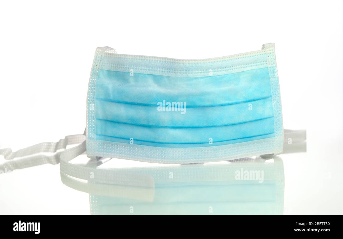 A NHS surgical medical face mask on a white background with a reflection Stock Photo