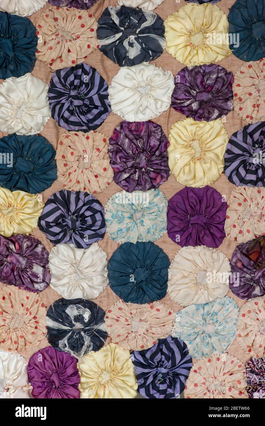 Antique quilt wall hanging.  Made from small fabric circles hand sewn and assembled to make a small covering. The actual size is 17' X 25'. Stock Photo