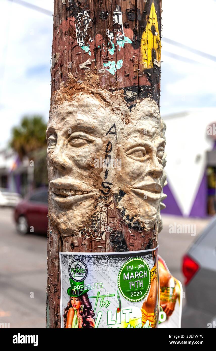 Two human faces sculptured with paper clay on a wooden post, Wynwood Art District, Miami, Florida, USA. Stock Photo