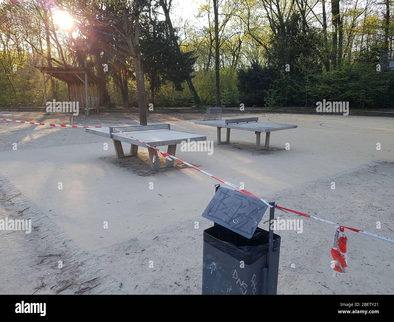 Empty, abandoned athletic ground public park with table tennis table / ping-pong closed by police barrier tape & warning sign - corona virus covid-19 Stock Photo