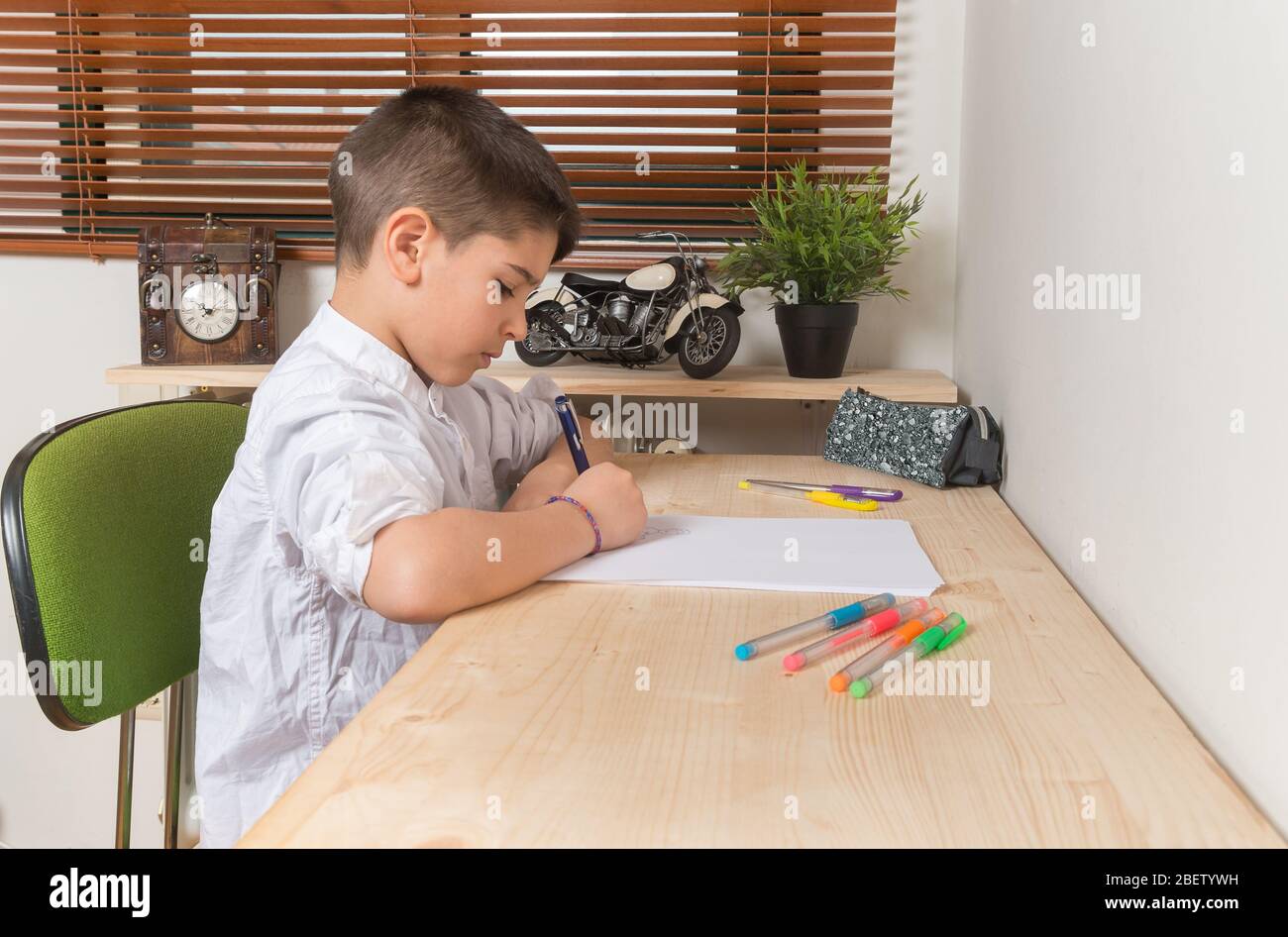 https://c8.alamy.com/comp/2BETYWH/young-8-year-old-boy-writing-and-drawing-on-paper-inside-home-2BETYWH.jpg
