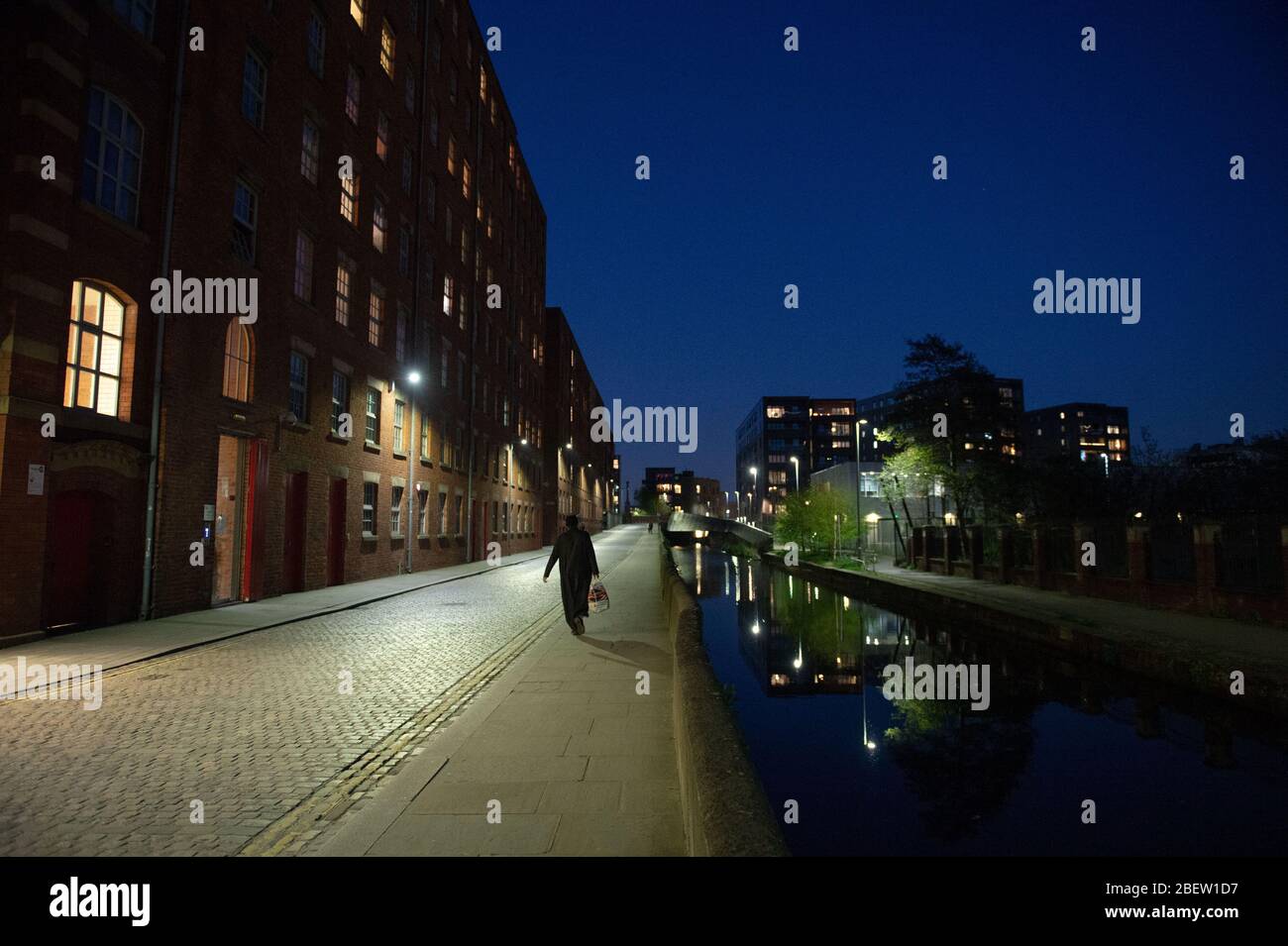 MANCHESTER, UK A solitary man returning home from the shop on a normally busy Redhill Street at twilight in Manchester city centre on Wednesday 15th April 2020. (Credit: Pat Scaasi | MI News) Credit: MI News & Sport /Alamy Live News Stock Photo