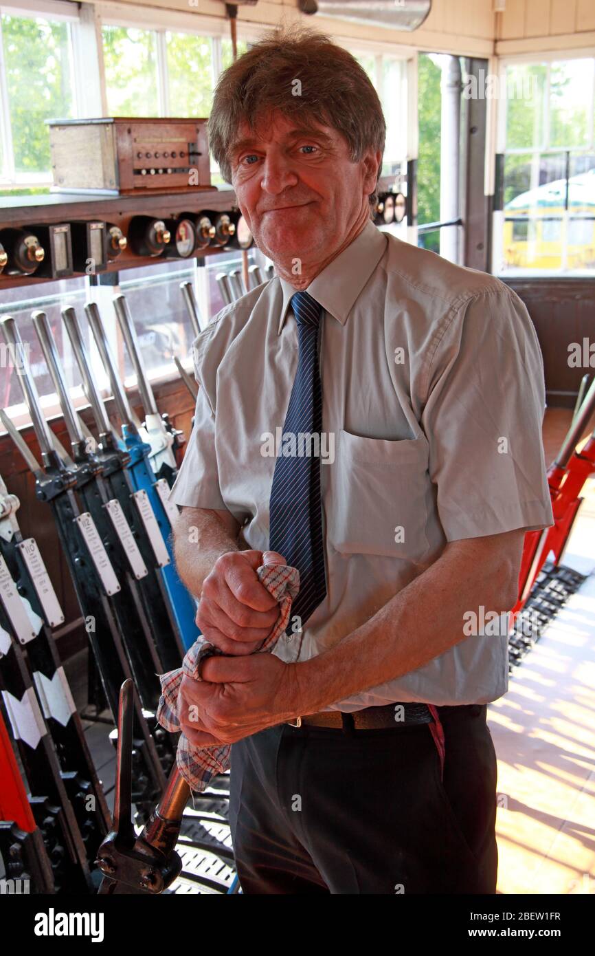 Working signalman in a 1950's style signal box, British Rail, Cheshire, England, UK, pulling levers Stock Photo