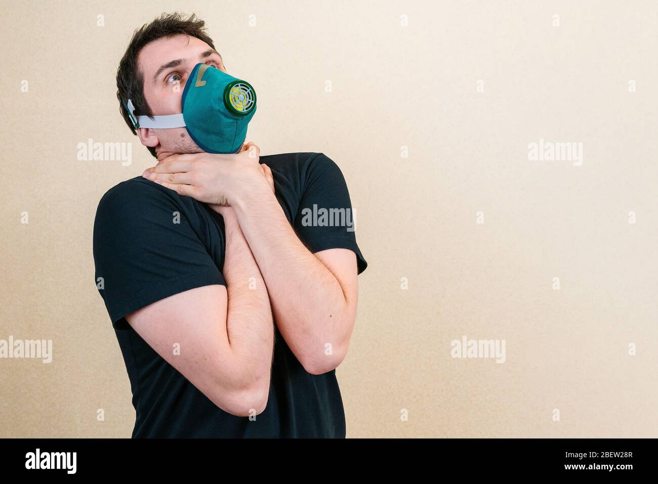 Young man in protective respirator mask cant breathe. Self-isolation and quarantine. Stay home Stock Photo