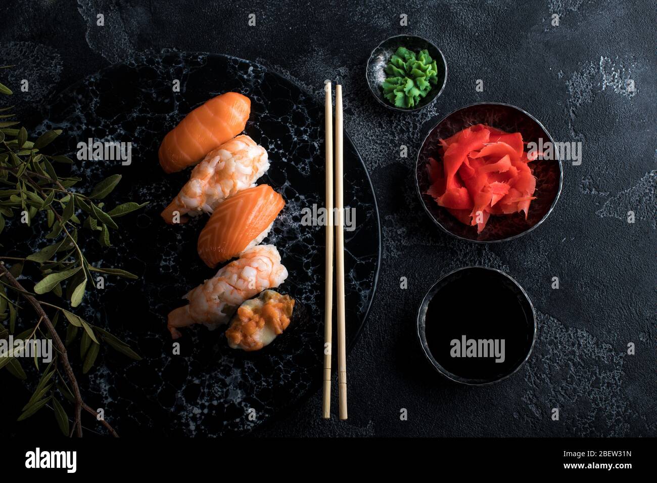 Delicious sushi set served on dark stone slate. Black background Stock