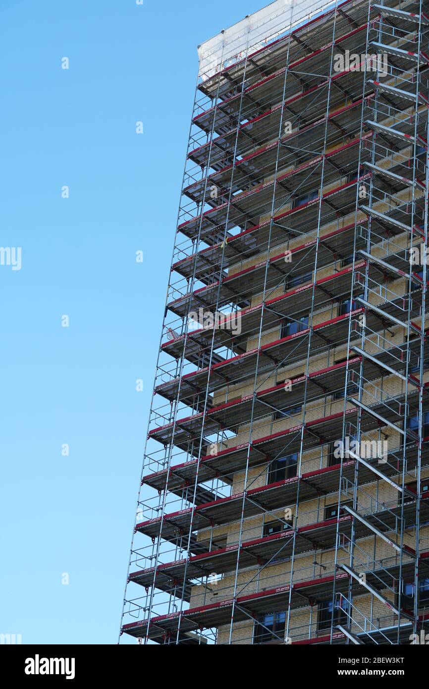 high apartment house in construction, rough building covered by ...