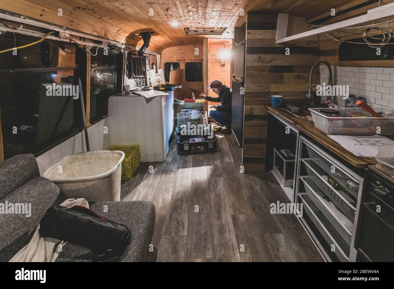 Wide angle view of man working converting a school bus into a house Stock Photo