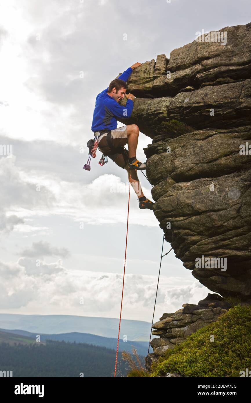 Rock climber on cliff at the Peak District in England Stock Photo