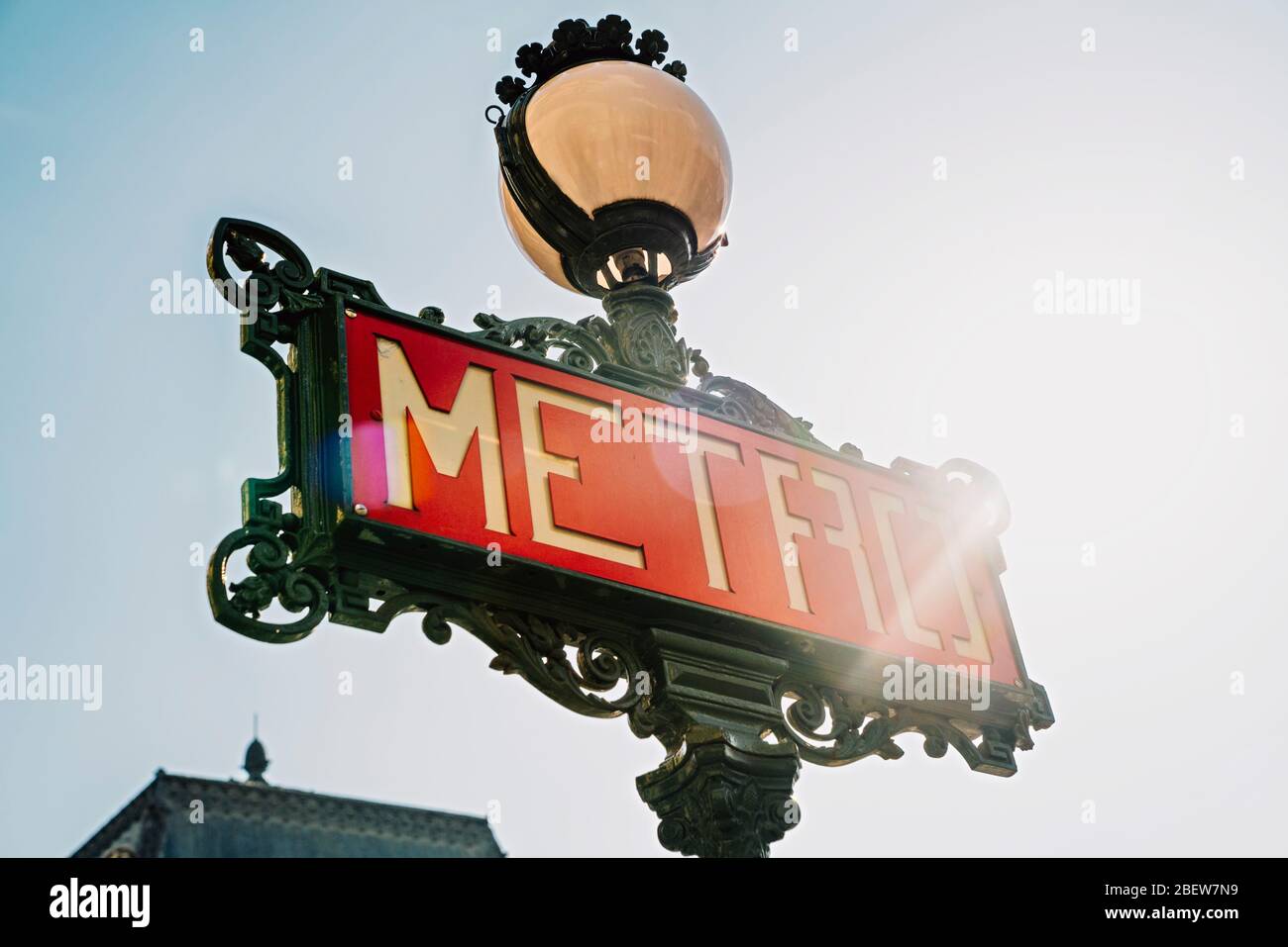Paris Metro sign with sunflare against blue sky Stock Photo