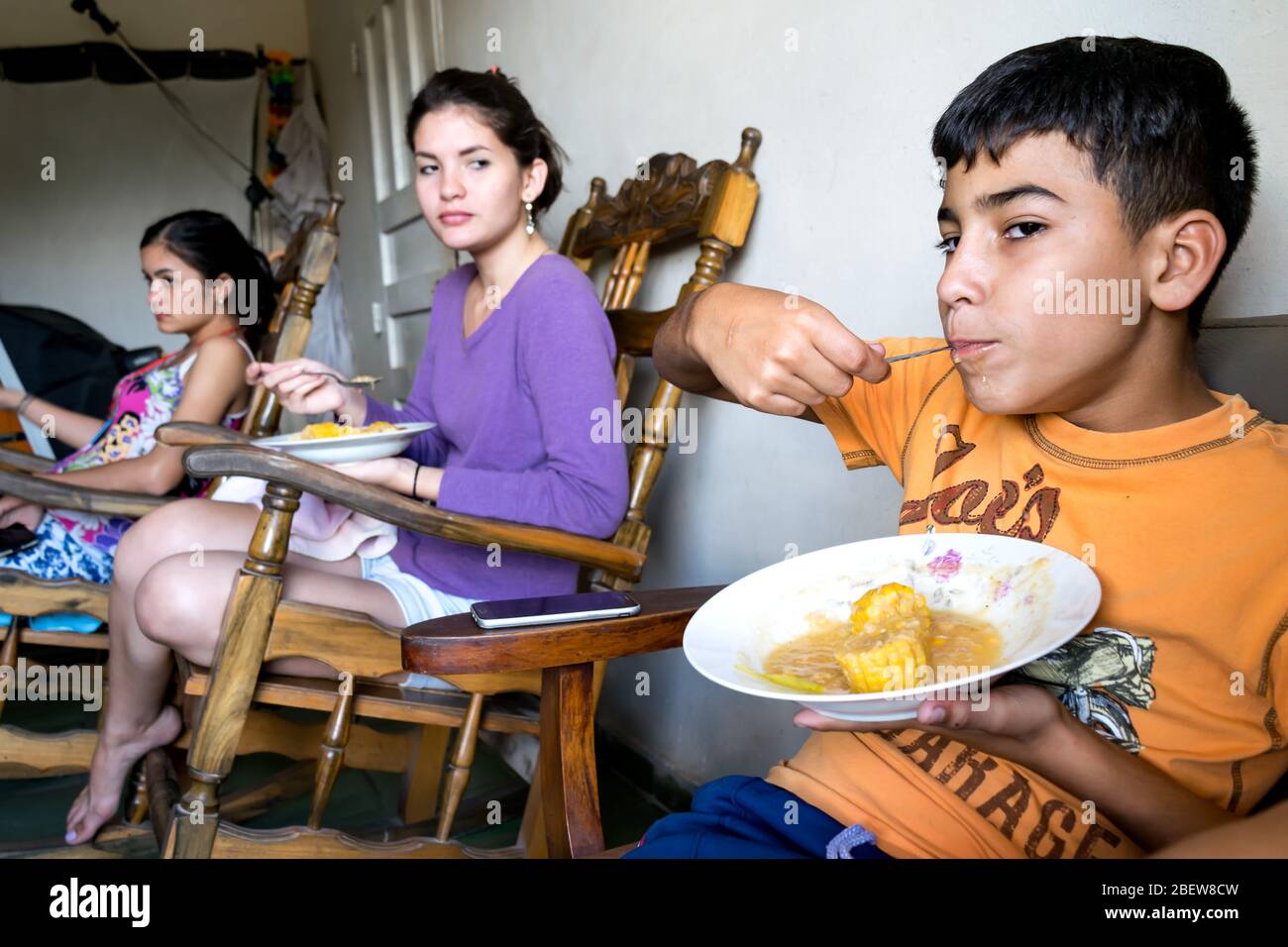 Actual scene of a latin family sharing lunch, they are having a traditional meal made out of corn. Stock Photo