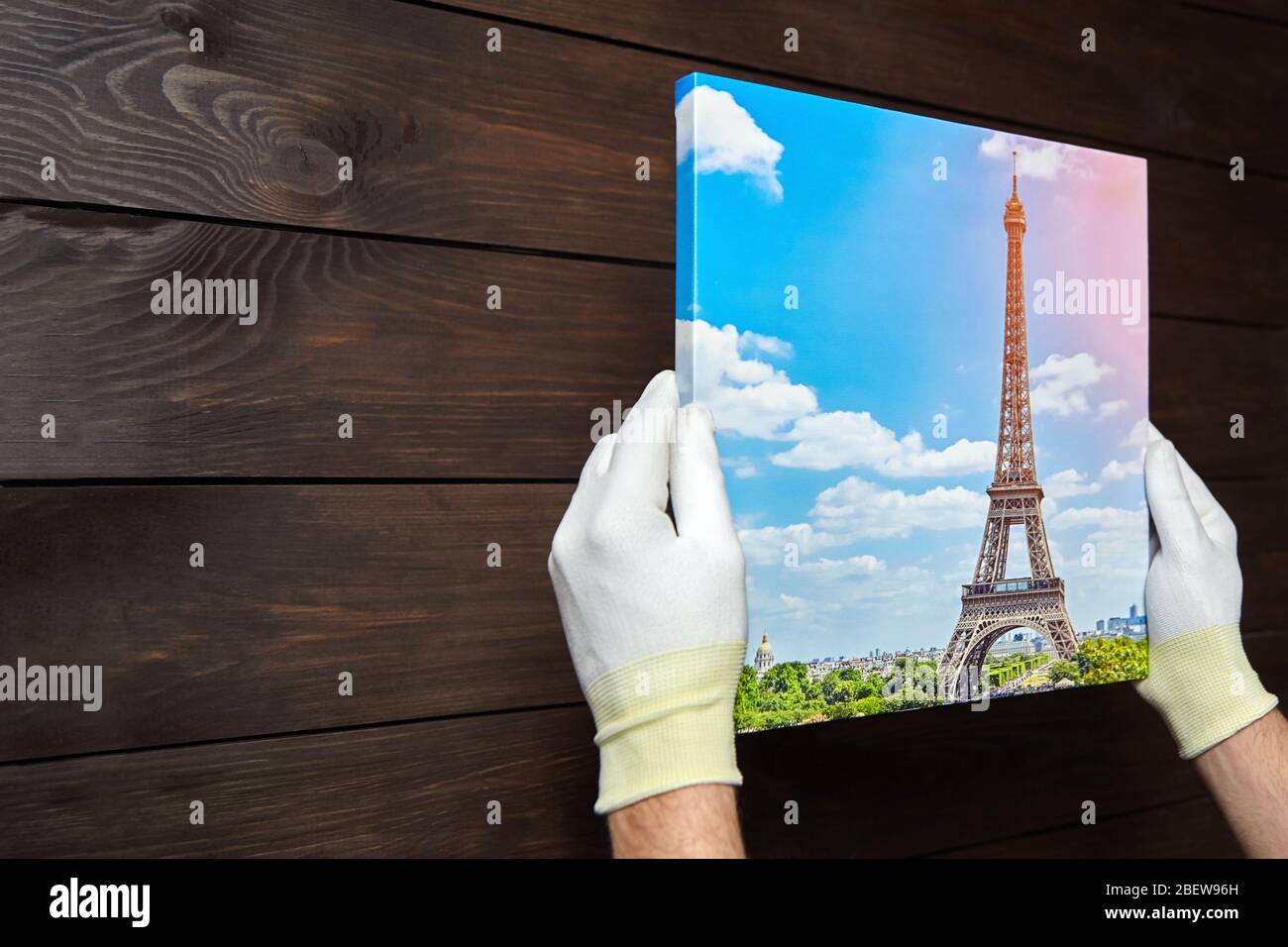 Photography printed on canvas with gallery wrap method of canvas stretching in male hands. Image of Eiffel Tower (Paris, France) Stock Photo