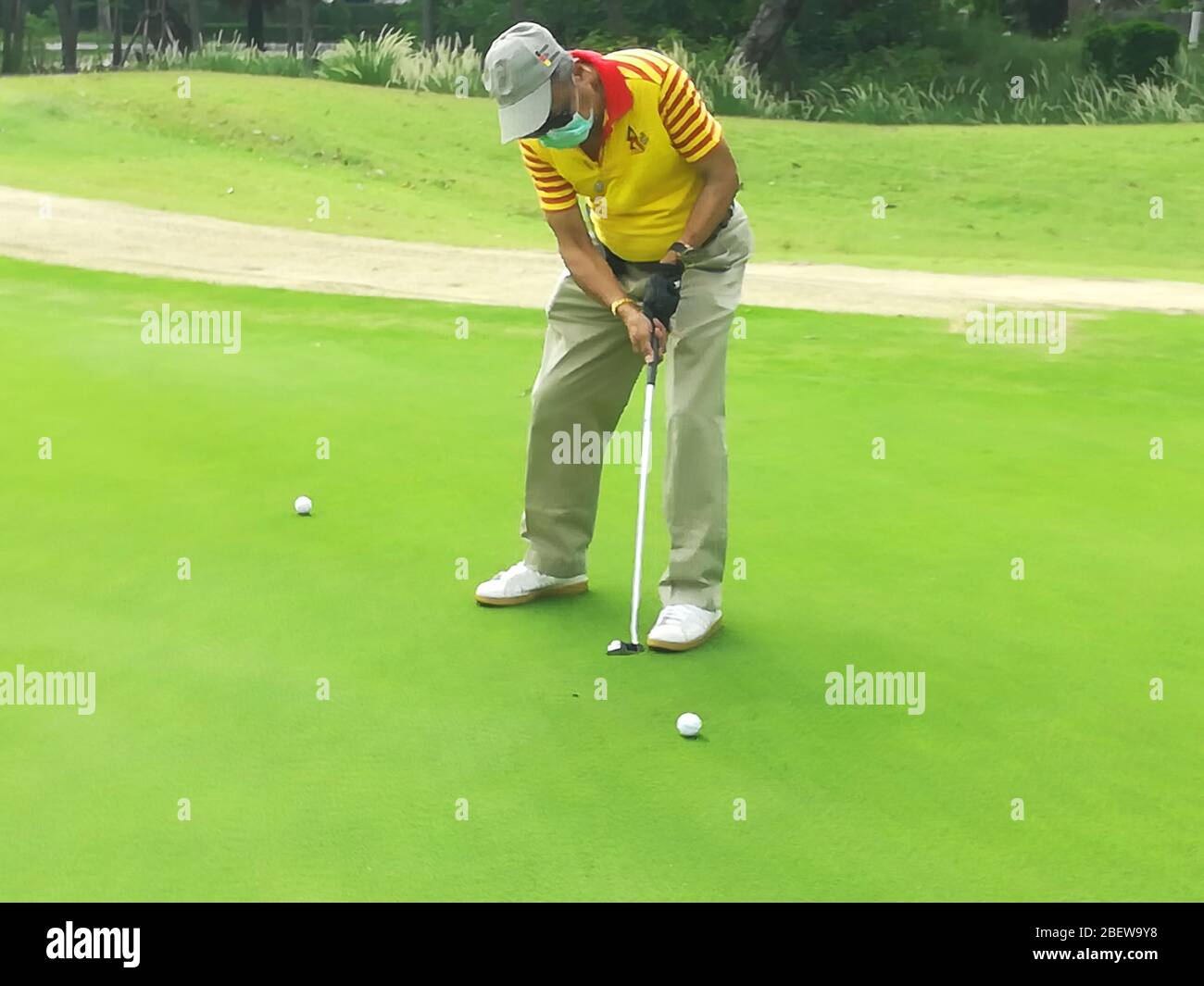 A golfer practices putting golf ball on green Stock Photo Alamy