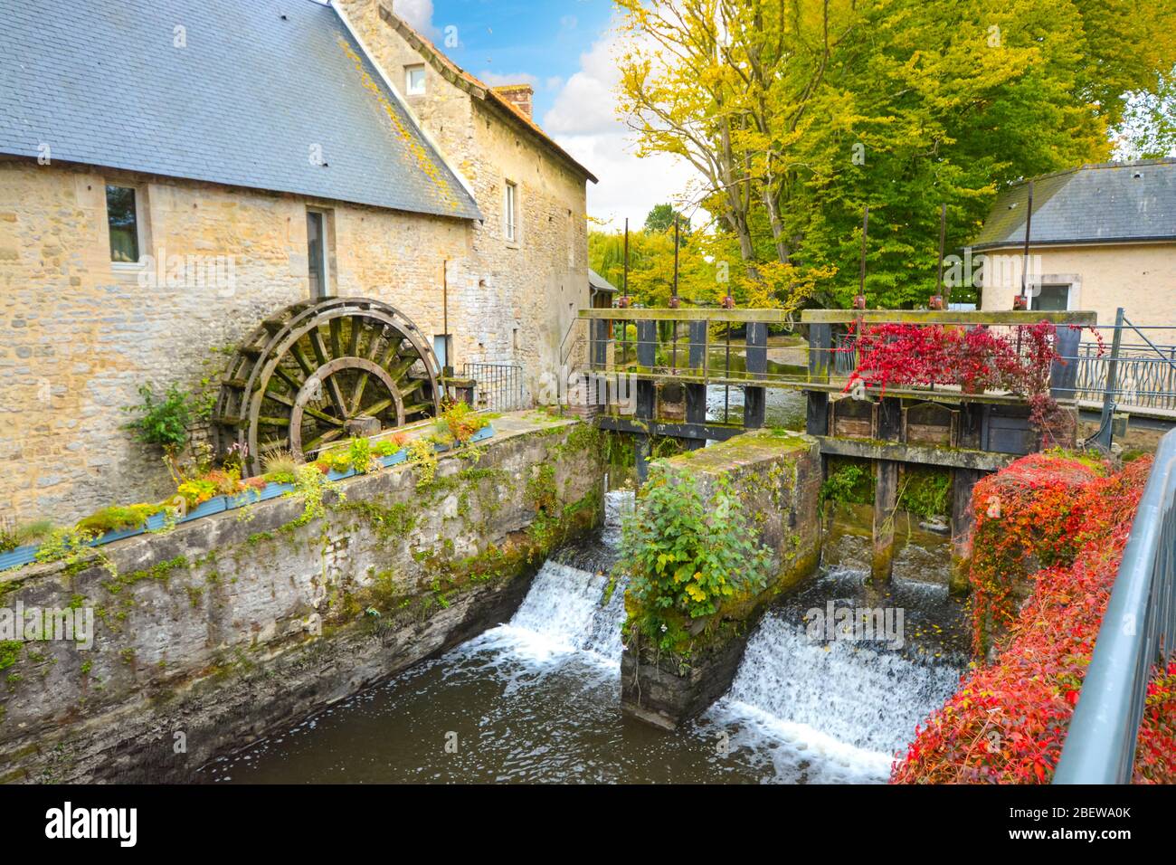 The water mill on the River Aure in the medieval town of Bayeux on the Normandy Coast of France, with bold autumn colors Stock Photo