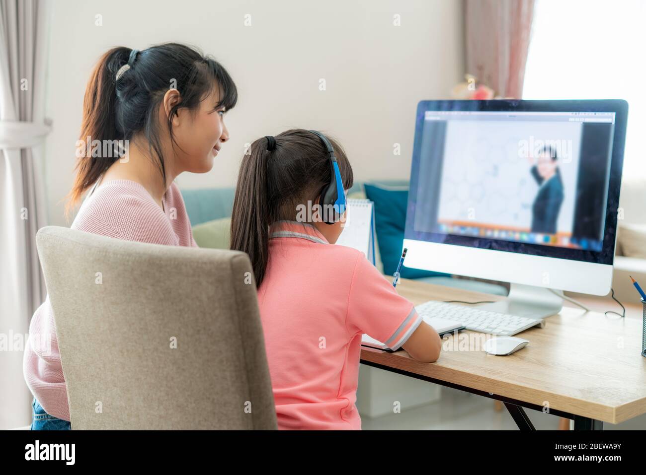 Asian girl student with mother video conference e-learning with teacher on computer in living room at home. Homeschooling and distance learning ,onlin Stock Photo