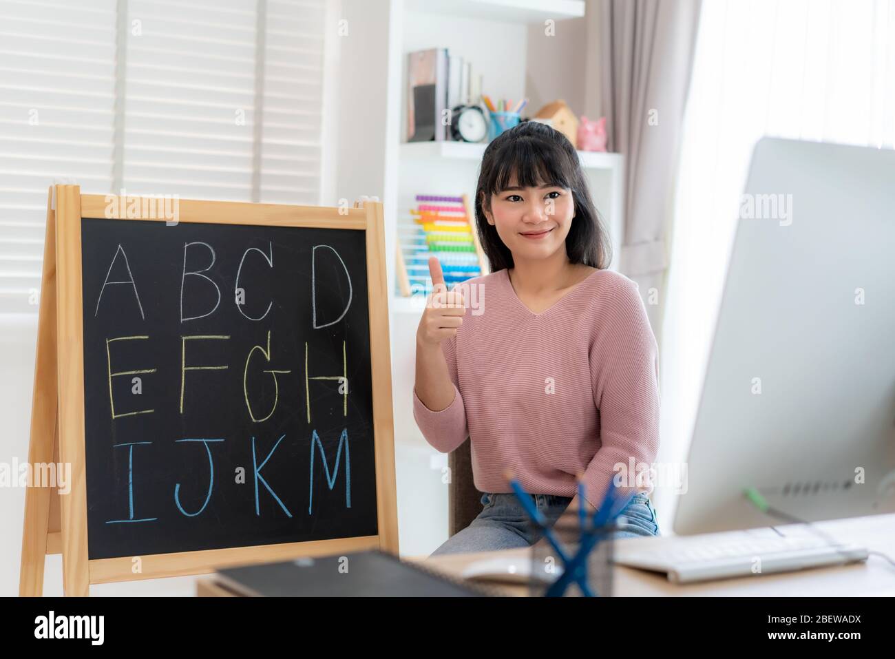 Asian woman teacher teaching English alphabet via video conference e-learning to elementary school student, Homeschooling and distance learning ,onlin Stock Photo