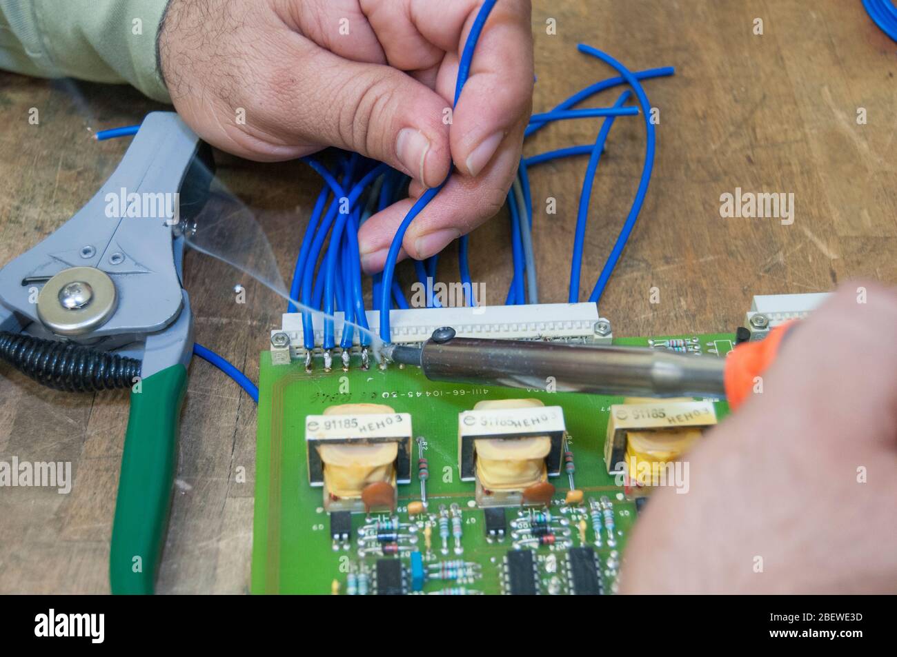 an electric technician with an electronic board performing maintenance as part of a skilled job workforce in the electric power and electronic industry Stock Photo