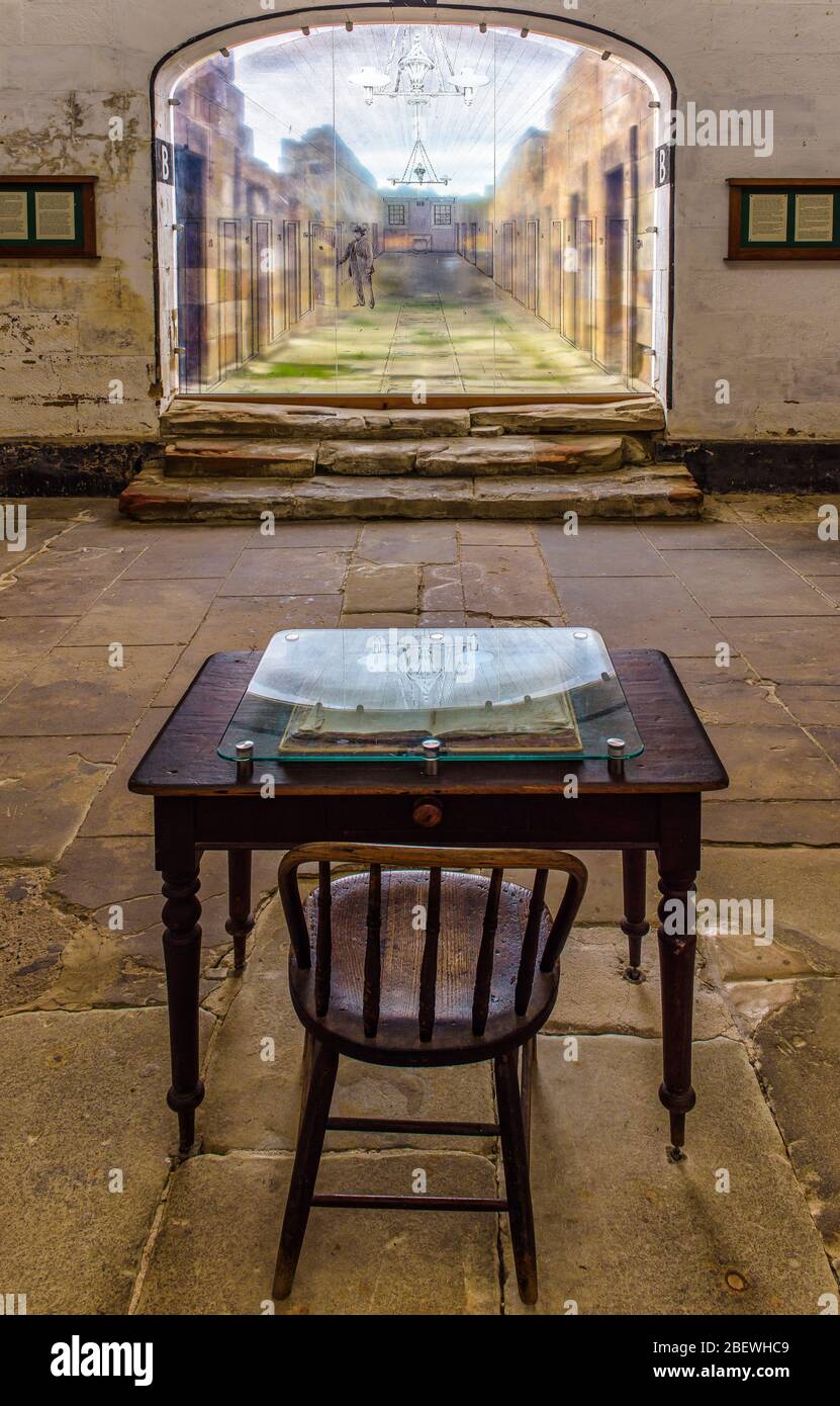 View from the guards station table and chair looking down the solitary confinement hall way at Port Arthur's penal colony ruins in Tasmania, Australia. Stock Photo