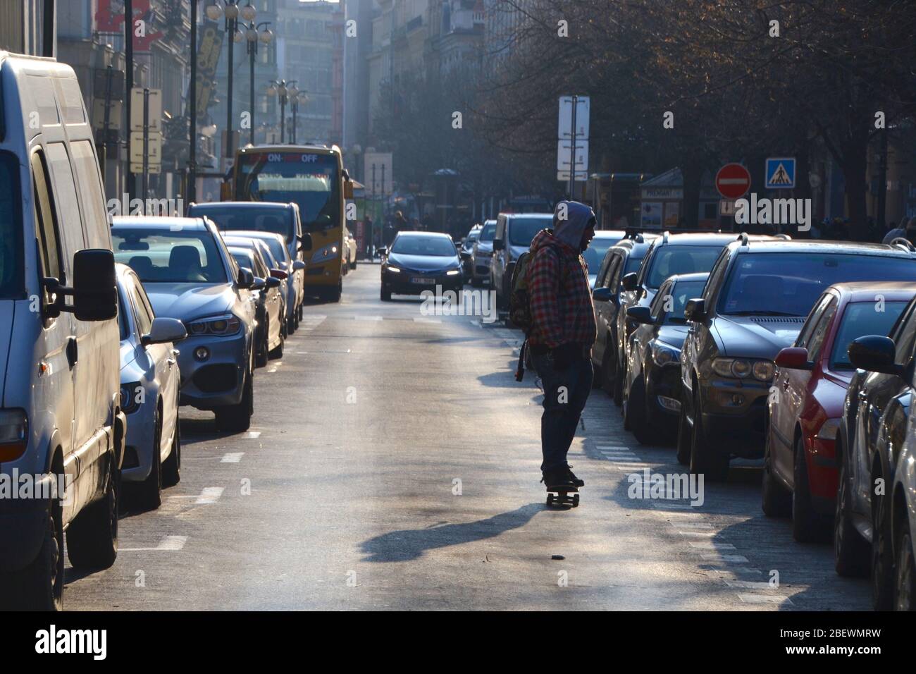 Lone skateboarder on an empty street in Europe with hoodie practicing social distancing Stock Photo