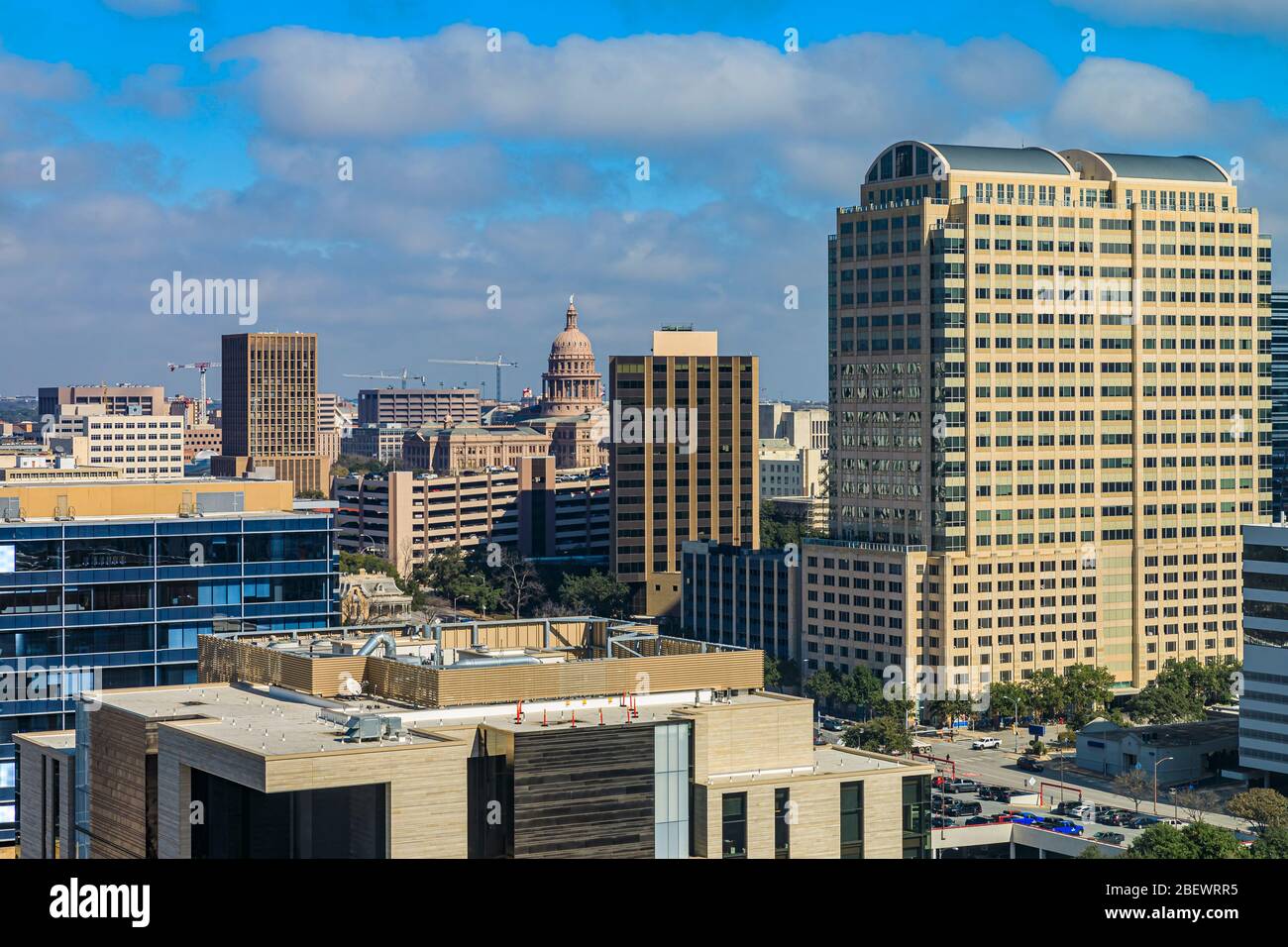 View onto modern new construction skyscraper buildings in downtown Austin, Texas with the state Capitol in the background Stock Photo