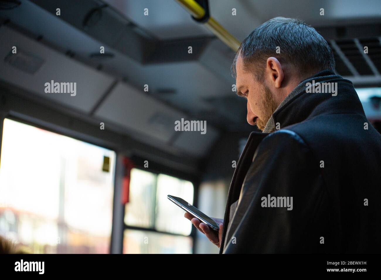 Vladivostok, Russia, March 24, 2020: a white man stands in a bus with a phone in his hands Stock Photo