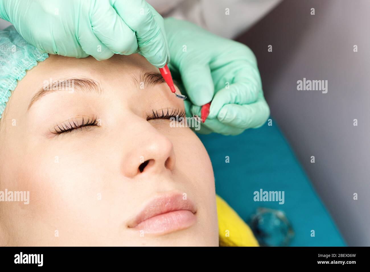 Young woman undergoing procedure of eyelashes lamination in beauty