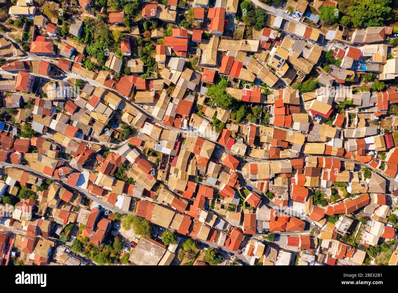 Aerial of ancient tiled rooftops in mediterranean Greece. Architecture of Corfu island from a drone. Red tiled roofs. Stock Photo