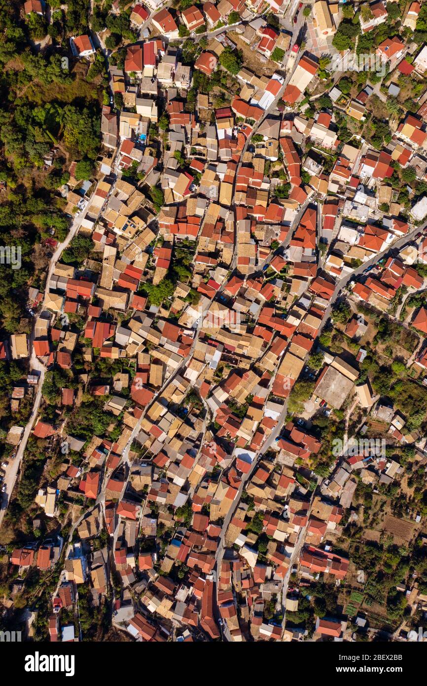 Aerial of meditarrean village from a drone. Old town on Corfu island, Greece. A shot of red and yellow tiled rooftops. Stock Photo