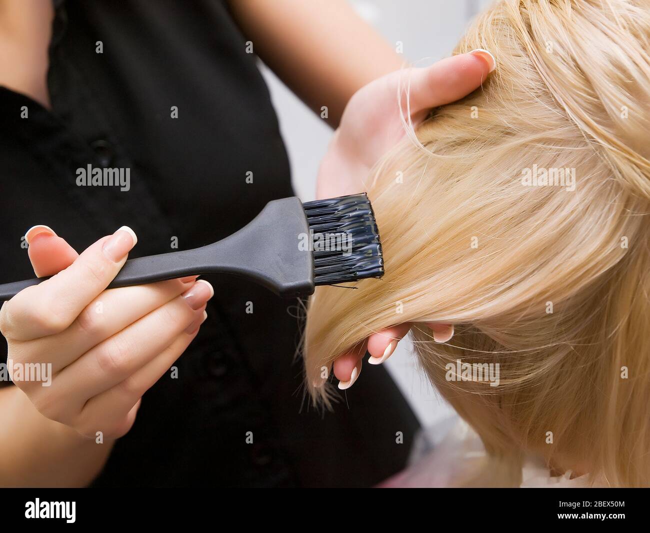 Hair coloring in a beauty salon in blonde. Hairdressing services. Stock Photo