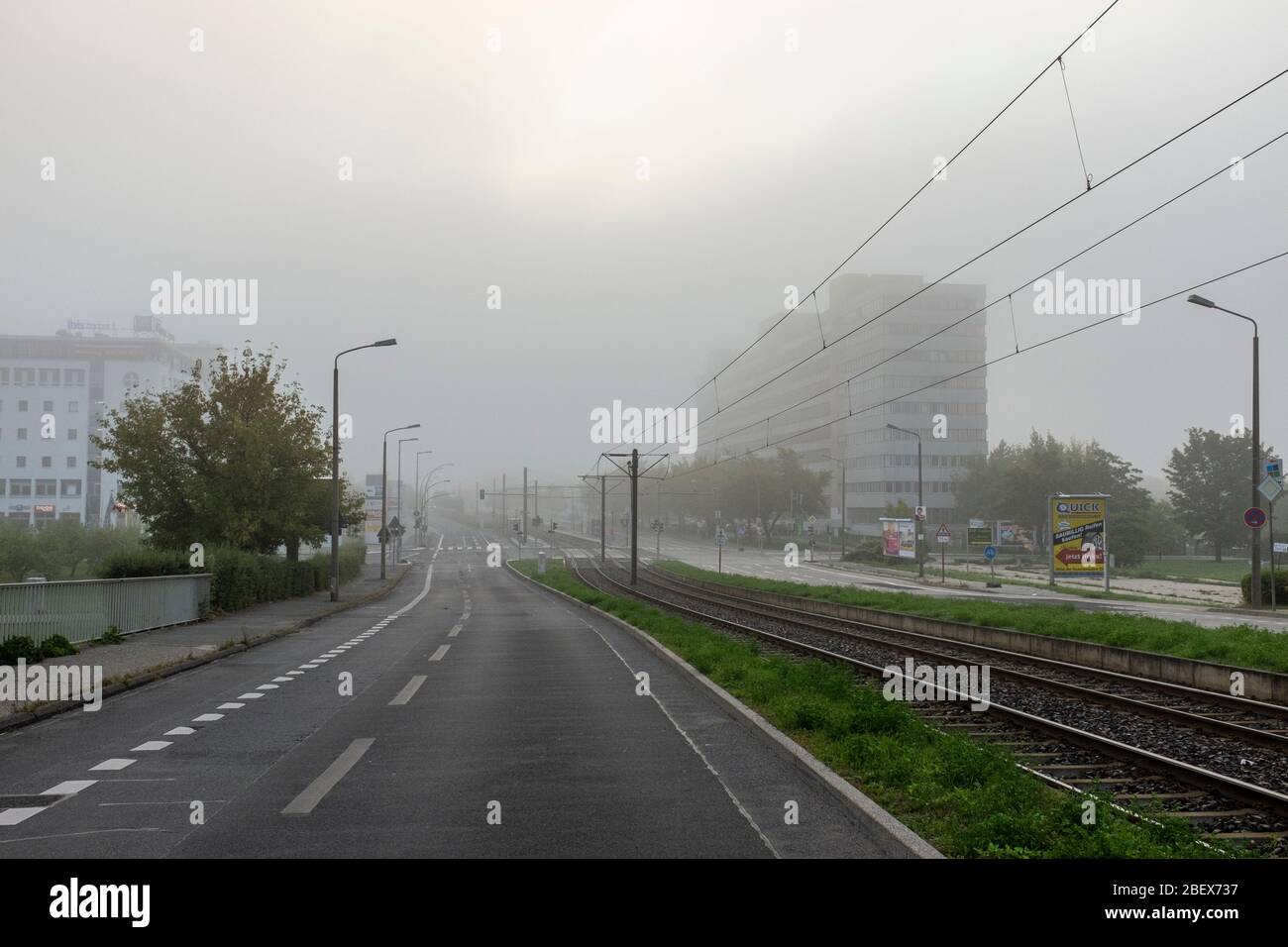 View along Allee der Kosmonauten on a foggy morning, Berlin, Germany Stock Photo