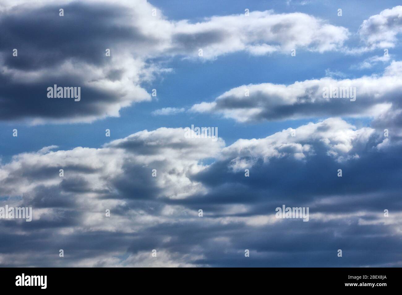 Blue sky with white and grey clouds Stock Photo - Alamy