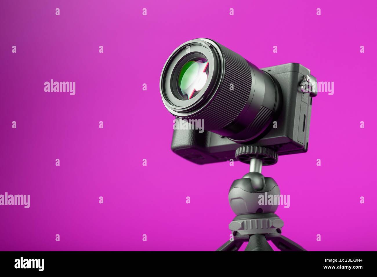 Professional camera on a tripod, on a pink background. Record videos and  photos for your blog or report Stock Photo - Alamy
