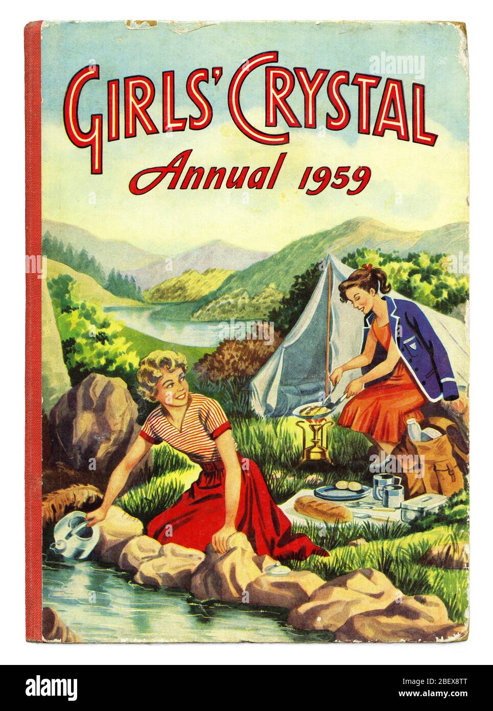 Cover of the Girls’ Crystal Annual 1959 published by The Amalgamated Press, London, England, UK. Annuals such as this were often the staple Christmas present of a British post-war childhood. Girls’ Crystal Annual featured two girls camping in an idyllic setting. They both wear dresses rather than more practical outdoor clothing. One girl is even wearing her school blazer whilst frying bacon on a camping stove and the other girl gets water in a kettle from a stream. Posh public (private) school children tended to feature in books of this era. Stock Photo