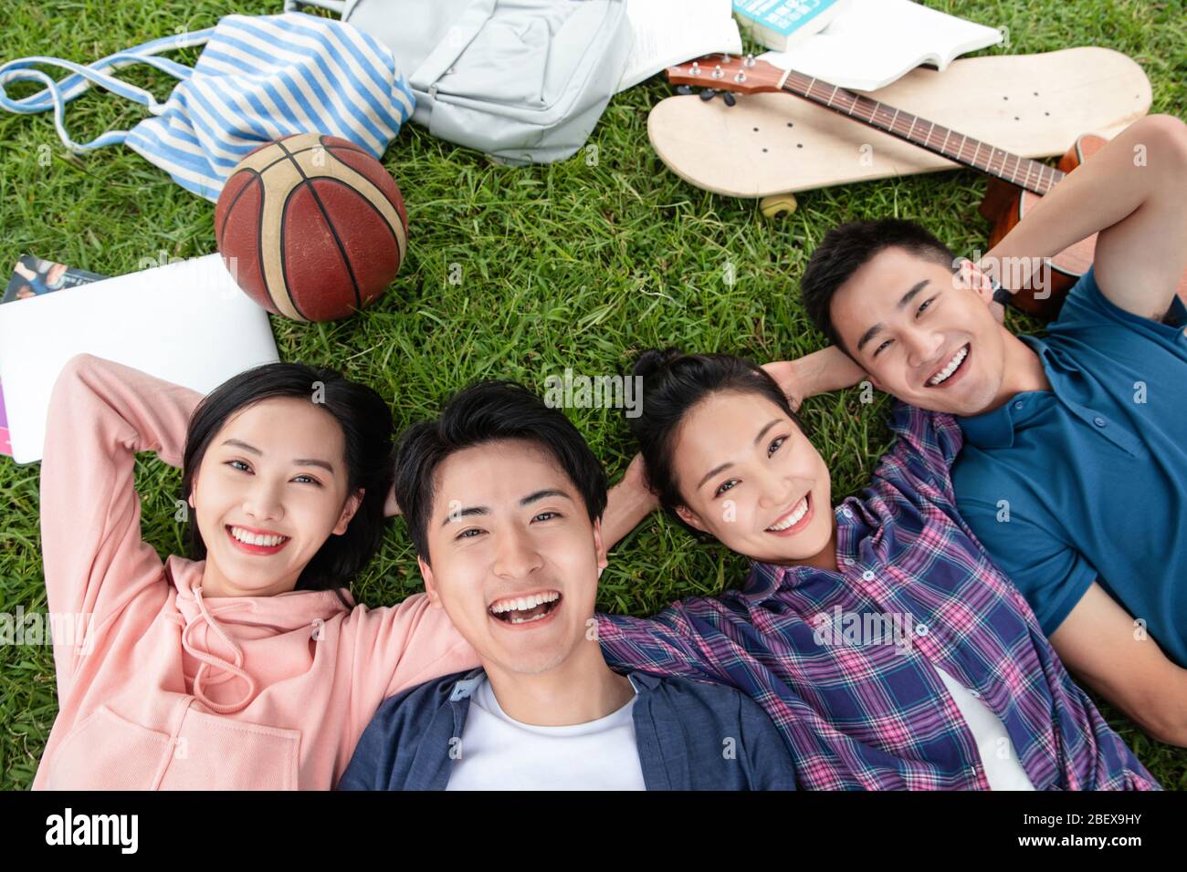 Happy students lay on the grass Stock Photo