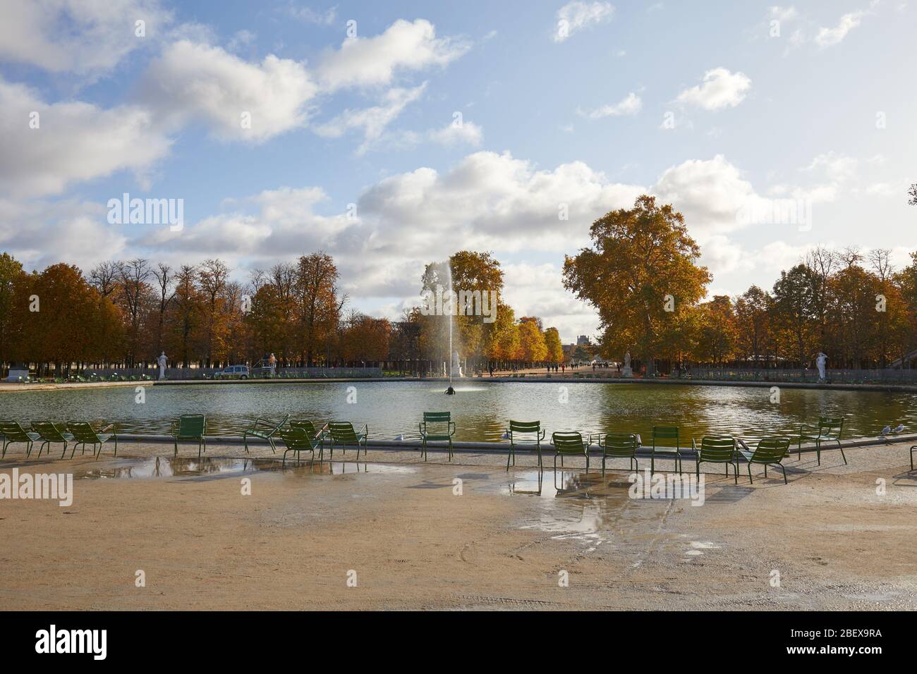 PARIS - NOVEMBER 7, 2019: Tuileries garden with chairs and fountain in sunny autumn in Paris Stock Photo