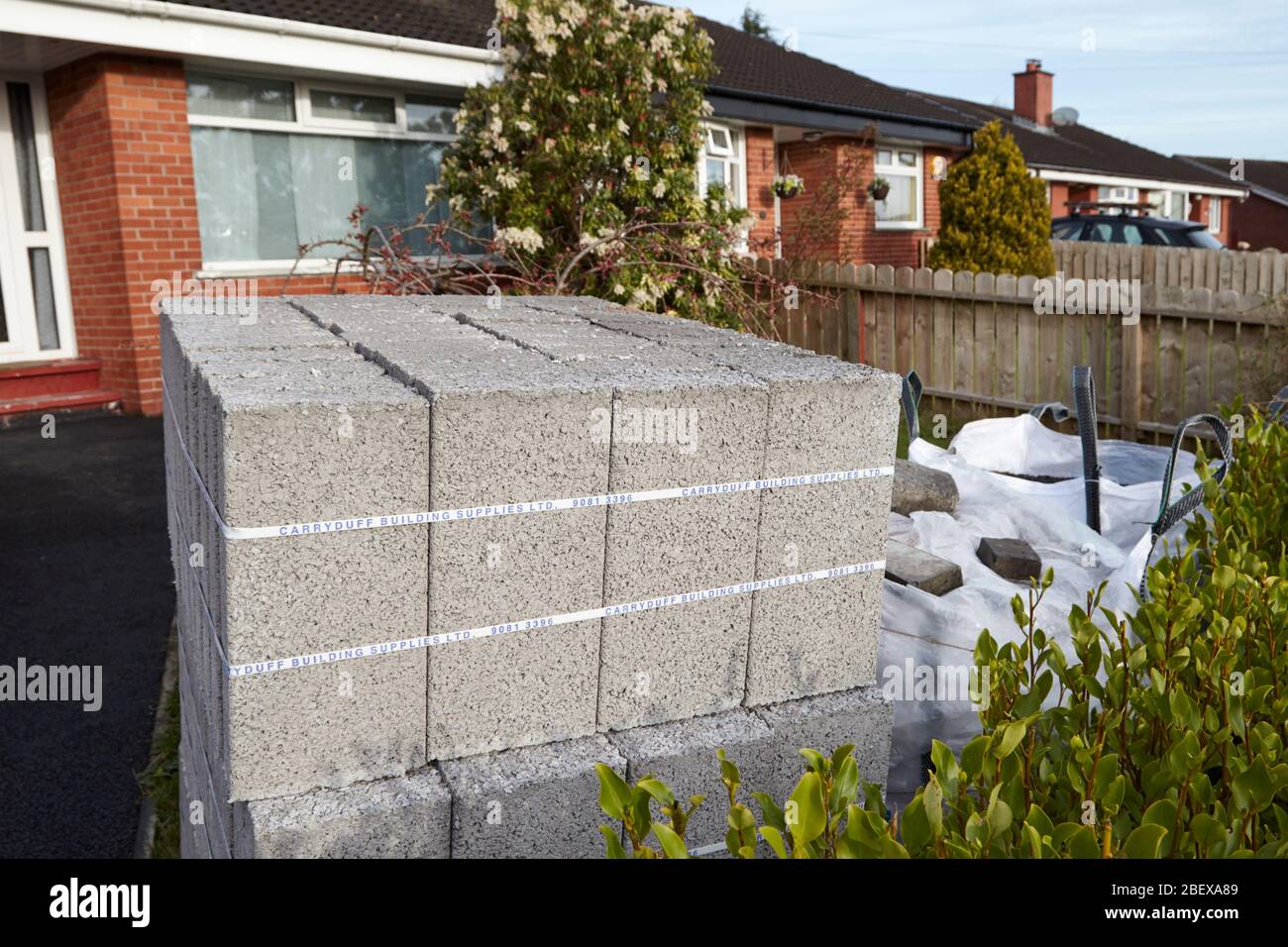 supply of building materials including concrete blocks sand and stones left in a garden of a house during covid lockdown Newtownabbey Northern Ireland Stock Photo