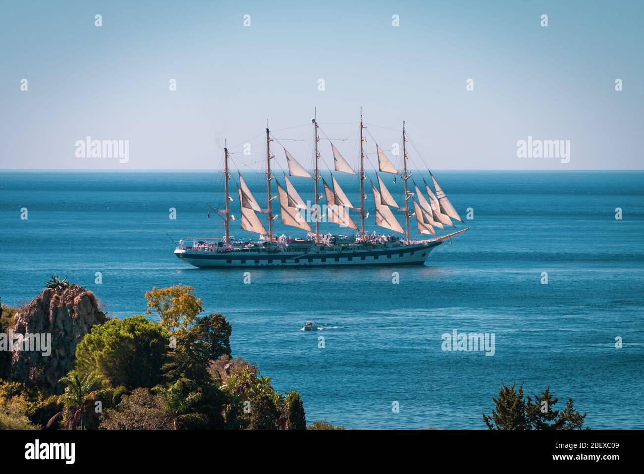 Beautiful old ship with many sails floating in the Mediterranean Sea near Isola Bella Nature Reserve, Taormina, Sicily, Stock Photo