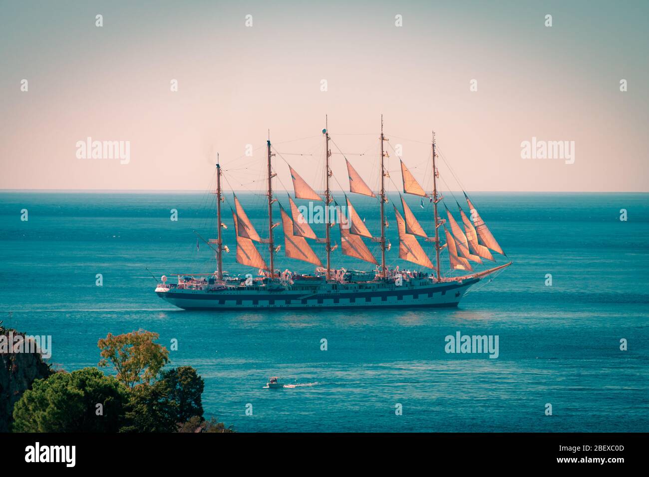 Beautiful old ship with many sails floating in the Mediterranean Sea near Isola Bella Nature Reserve, Taormina, Sicily, Stock Photo