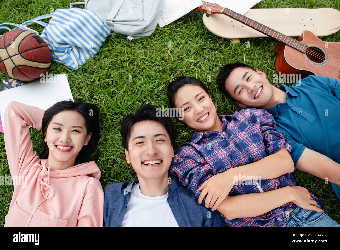 Happy students lay on the grass Stock Photo