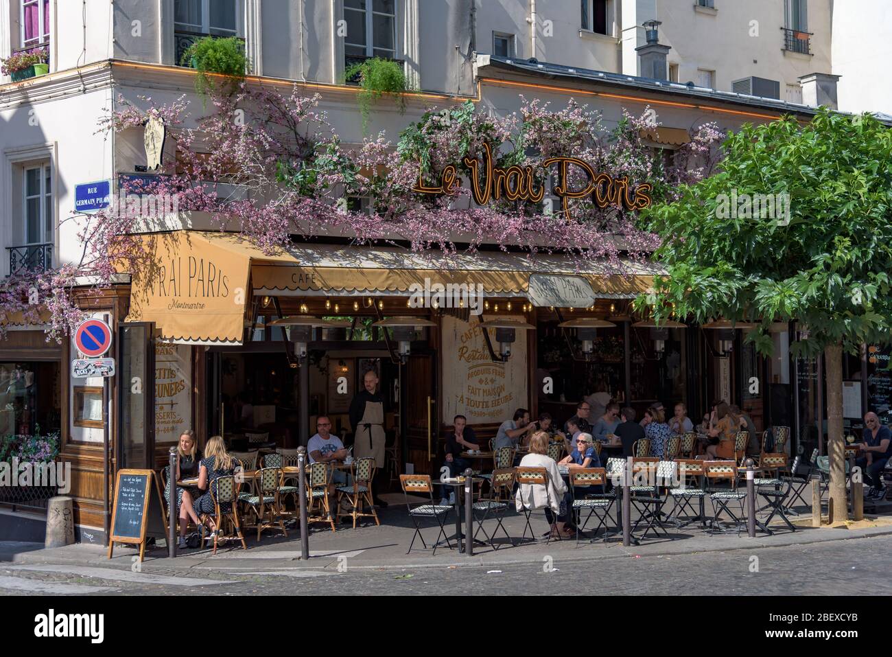 The restaurant 'Le Vrai Paris' on a typical street in the Montmartre district with crowds of tourists, near the Basilica of the Sacre Coeur in Paris. Stock Photo