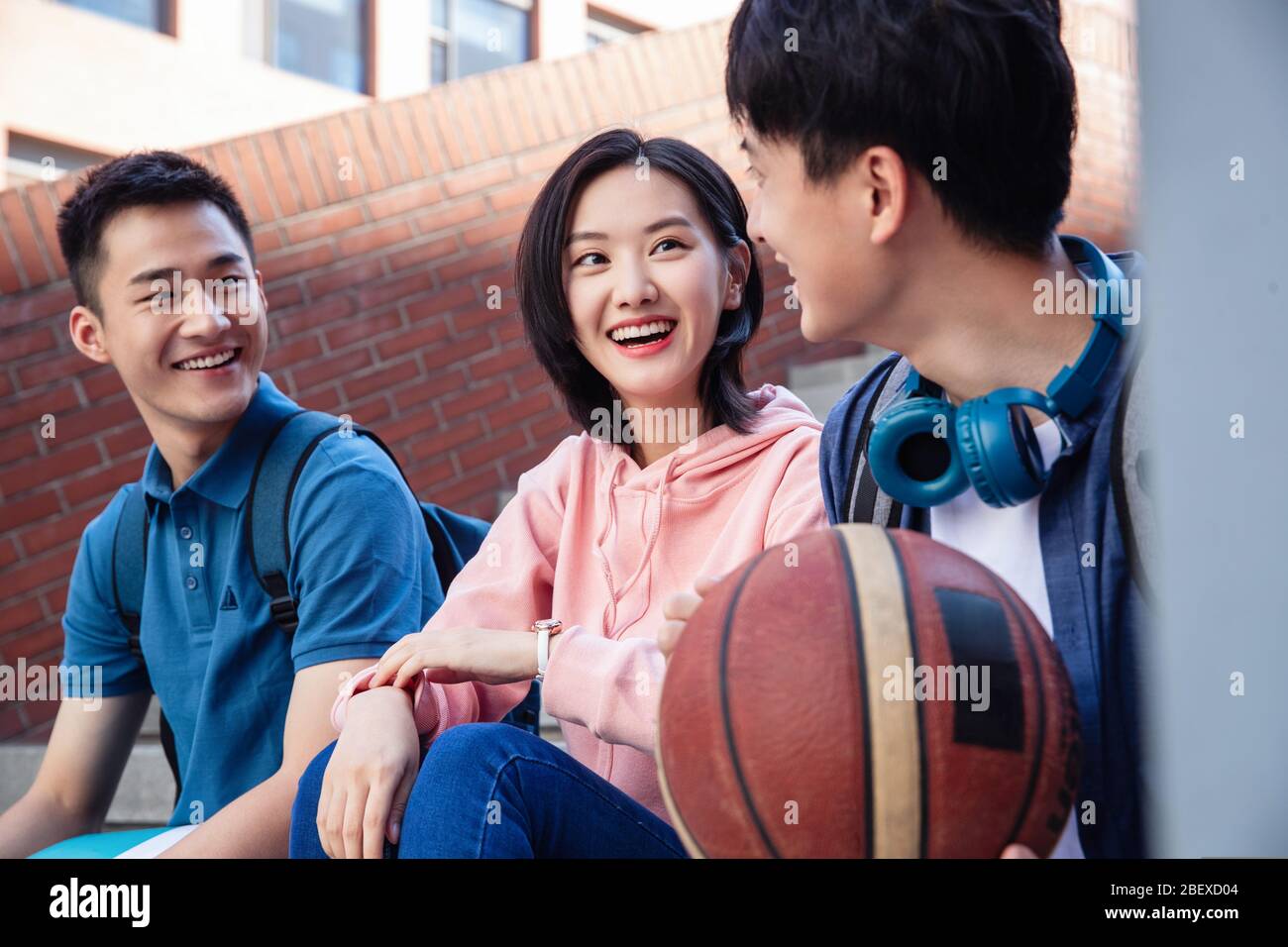 Happy students sit chatting on the stairs Stock Photo
