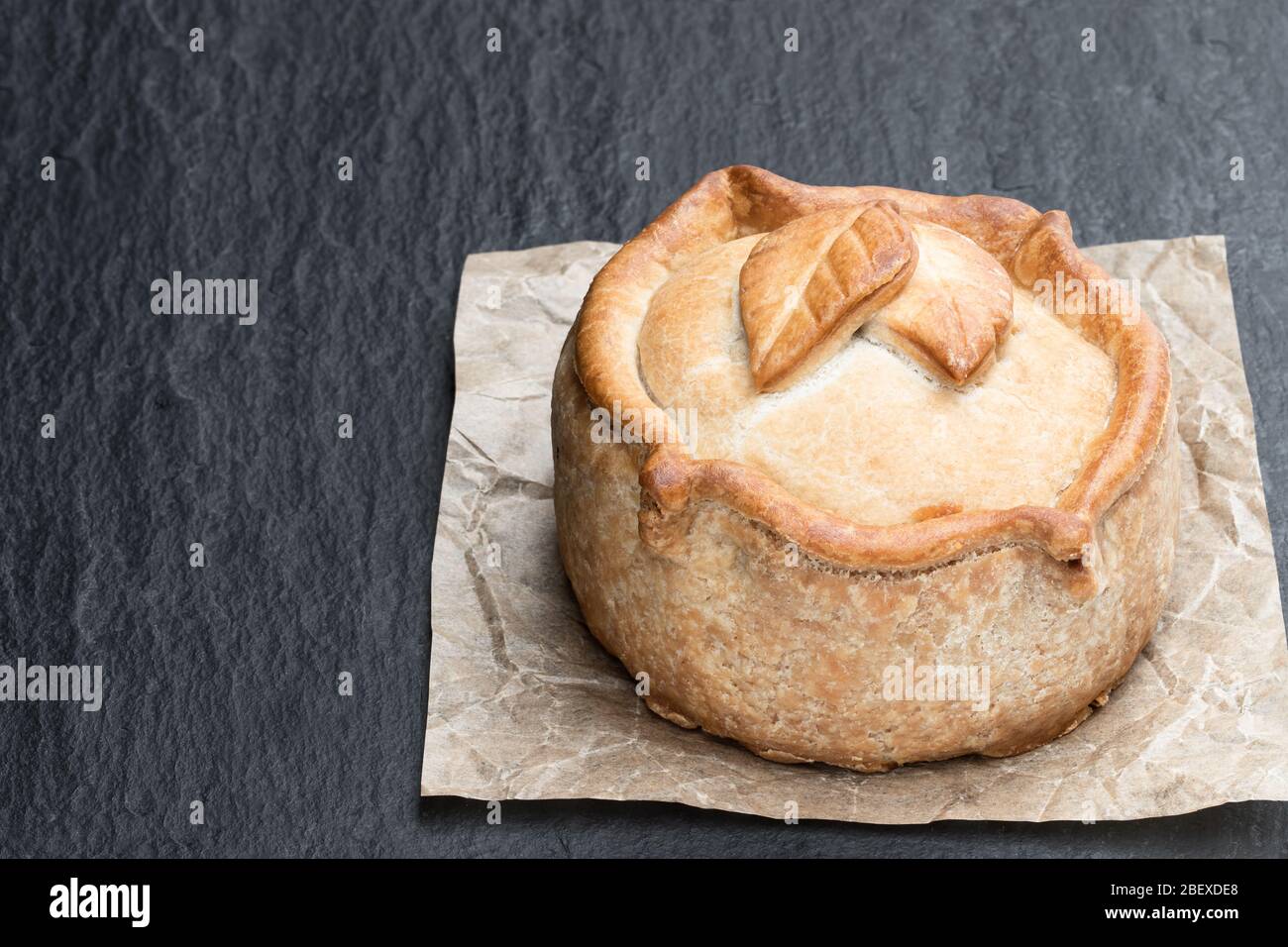 Seasoned cured pork and ham pie on black stone background Stock Photo