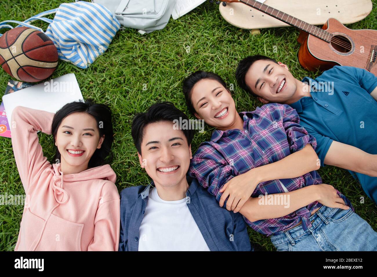Happy students lay on the grass Stock Photo