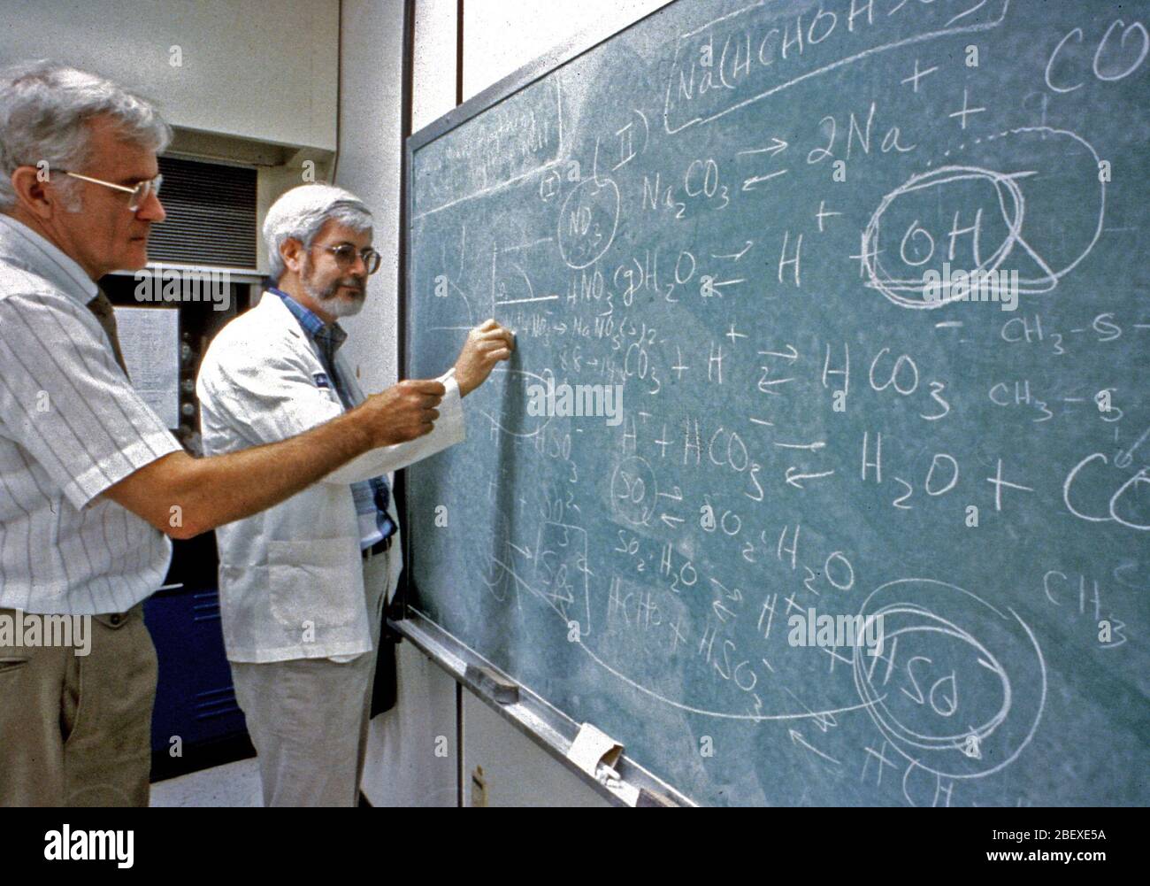 EPA scientists analyzing formulas on chalkboard ca. 1996 Stock Photo ...
