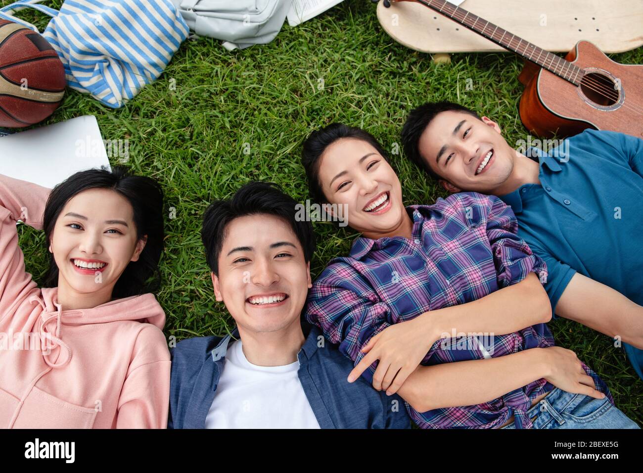Happy students lay on the grass Stock Photo