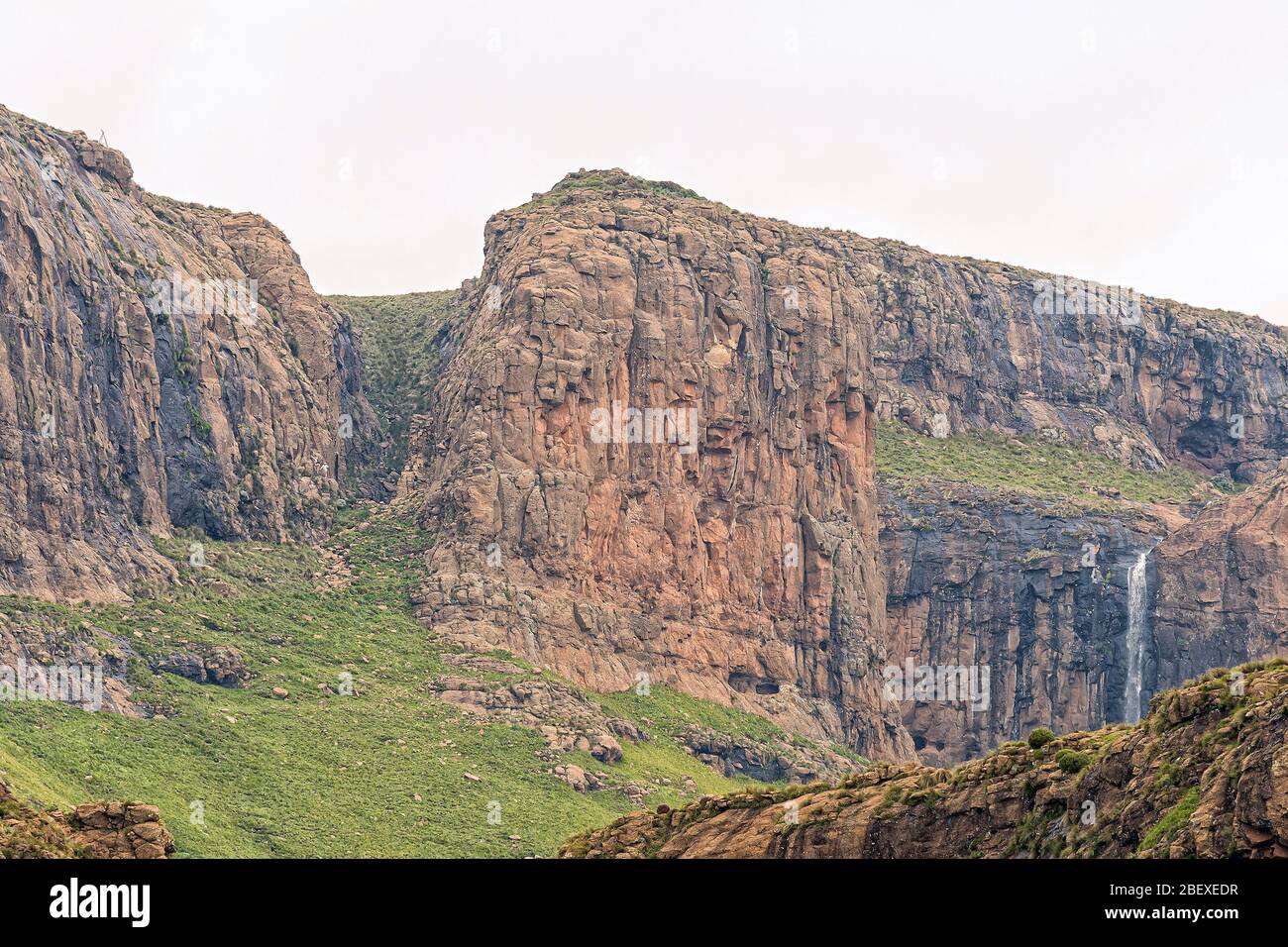 People are visible on the bottom chainladders on the Sentinel hiking trail to the Tugela Falls. A waterfall is visible Stock Photo