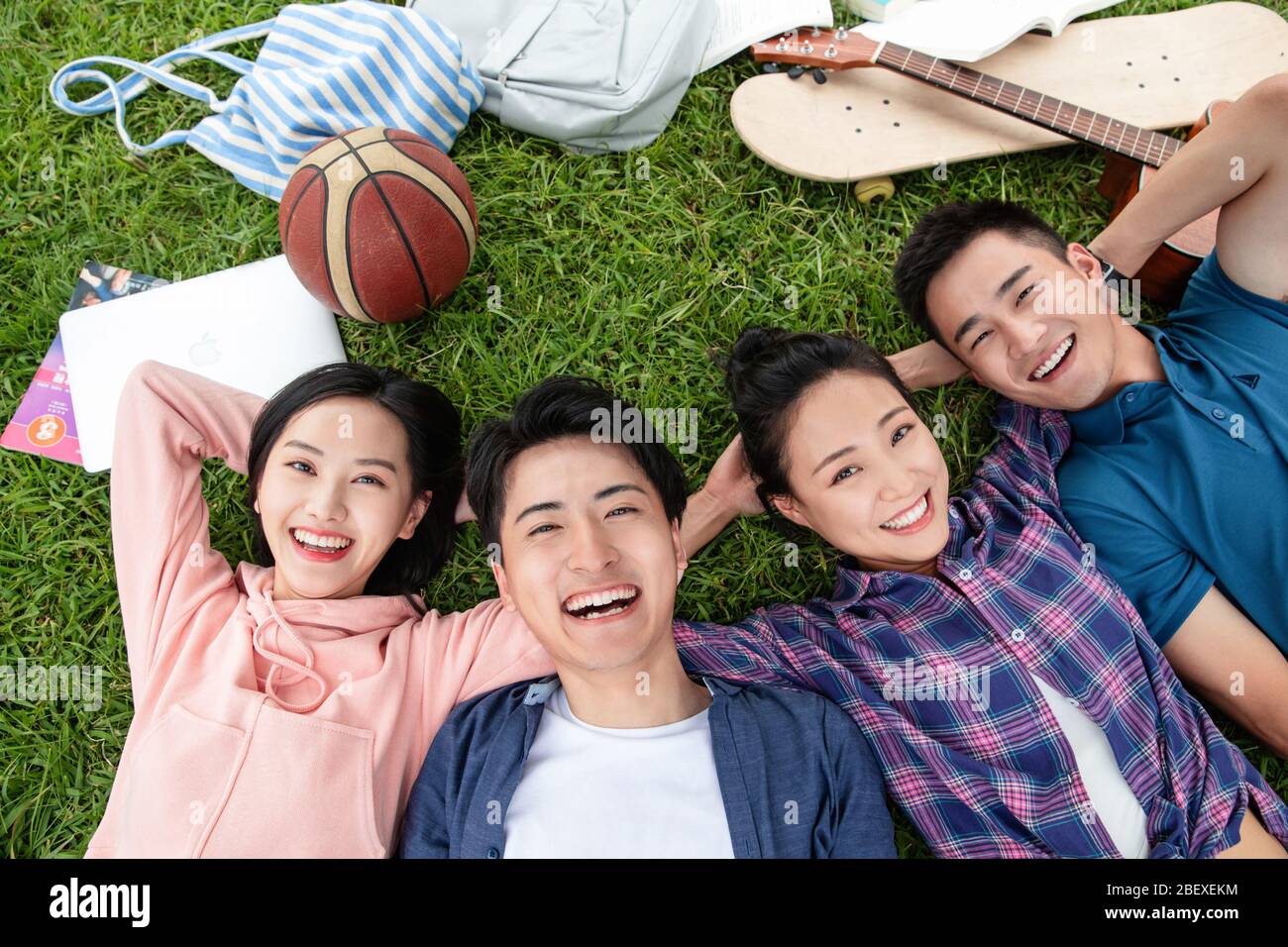 Happy students lay on the grass Stock Photo