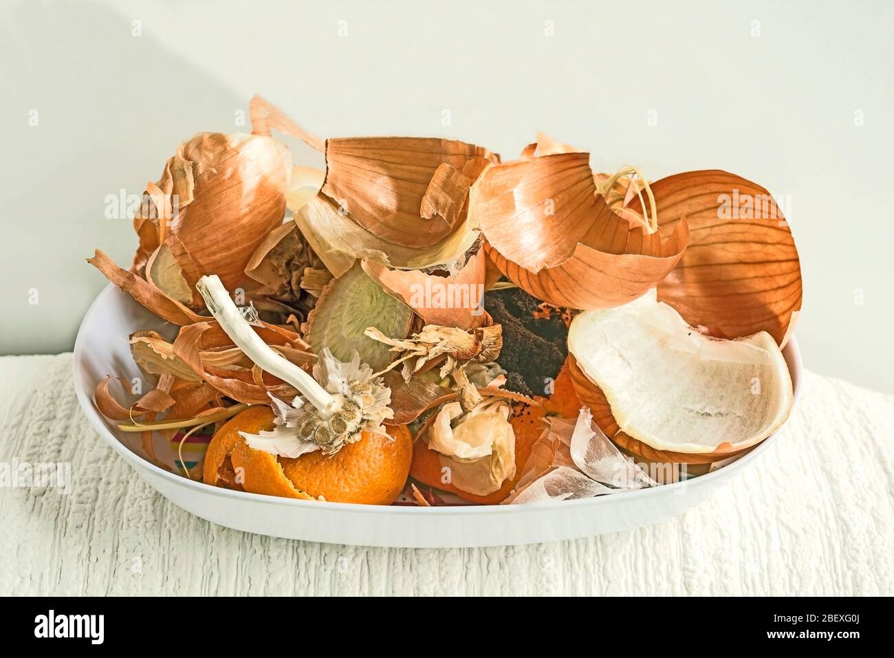 Onion peel, coffee grounds, tea bags and garlic stem, orange peel in white bowl against white background. Concept composting, Eco-friendly, recycling. Stock Photo
